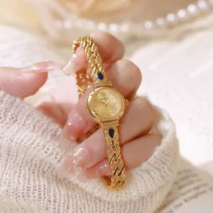 Detalle exquisito de un lujoso reloj de mujer dorado con circonitas azules y brazalete