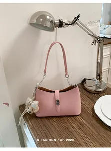 Primo piano della borsa sottobraccio in pelle rosa con catena argento e ciondolo