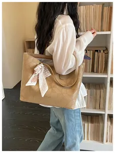 Close-up of a khaki geometric embossed tote bag featuring a stylish silk scarf.