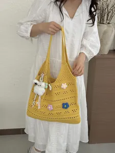 Detail der gelben Strick-Tote-Bag mit bunten Häkelblumen-Applikationen.