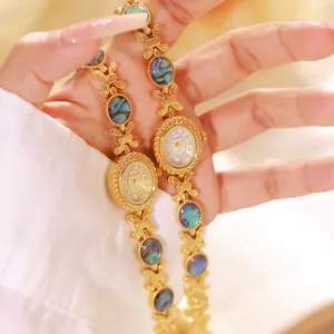 Primer plano de un reloj de pulsera de oro de lujo con incrustaciones de abulón