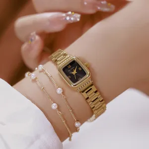 Primer plano de elegante reloj de mujer en acero dorado con esfera negra y pulsera de perlas