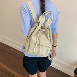 Detalle de la mochila beige con cordón que muestra su diseño de gran capacidad