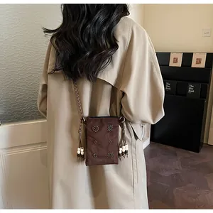 Back view of brown velvet crossbody phone bag with floral bead studs and cord strap