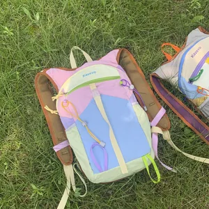 Detailed view of a colorful dopamine style outdoor hiking backpack on a green lawn.