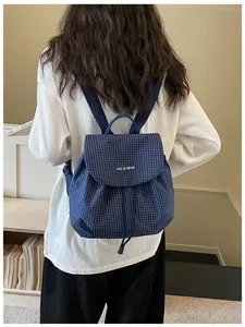 Women's blue grid mini backpack styled with a casual outfit for daily commuting.