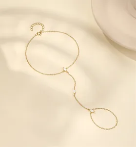 Gros plan sur un bracelet de doigt en argent doré orné de zircons taille marquise