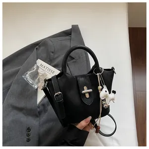 Détail d'un sac seau noir chic avec un pendentif cheval et des finitions argentées
