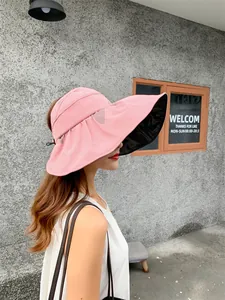 Side view of a pink wide-brim sun hat with black UV protection lining