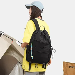 Détail d'un sac à dos noir à cordon en situation extérieure avec broderie élégante