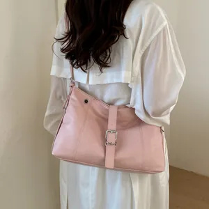 Rear view of a stylish pink leather shoulder bag worn over a white linen shirt