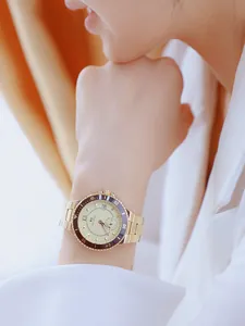 Detalle de un reloj Bee Sister de acero inoxidable dorado en la muñeca de una mujer