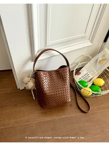 Macro view of the elegant brown woven leather texture on this vintage women's bucket bag