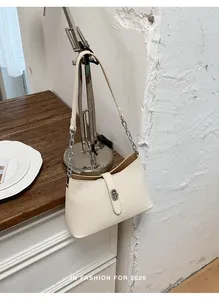 Vista dettagliata di un'elegante borsa sottobraccio beige crema con catena argento