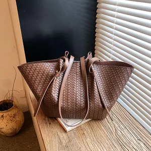 Elegant woven brown leather tote bag with minimalist long shoulder straps for modern women