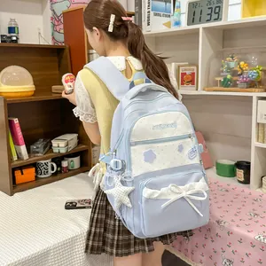 Back view of cute light blue student backpack with star prints and white bow detail