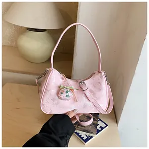 Detail view of pink butterfly pattern underarm bag with a traditional fortune charm