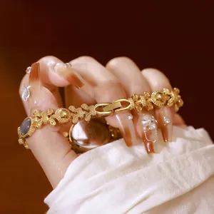 Primer plano de elegante reloj de pulsera dorado con incrustación de concha de abalón.