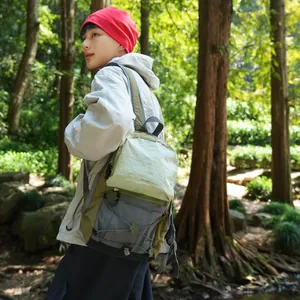 Detailansicht eines leichten wasserfesten Outdoor-Rucksacks, der in einem Wald getragen wird.
