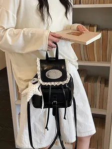 Elegante zwarte glanzende rugzak met witte kantafwerking en een mooi sterrenbedeltje