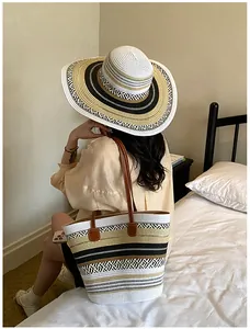 Detailansicht einer stilvollen gestreiften Strohtasche mit passendem Sonnenhut mit Krempe
