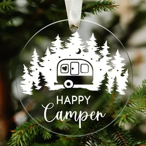 Detail view of a round acrylic Christmas ornament featuring a 'HAPPY Camper' forest design