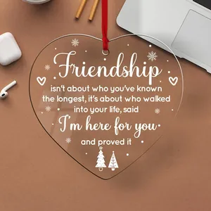 Close-up of heart-shaped acrylic ornament with friendship quote and red ribbon