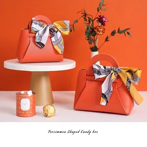 Élégante boîte à bonbons en cuir orange en forme de persimmon pour cadeaux de mariage.