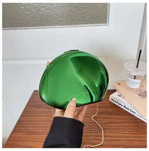 Dettaglio di una pochette da sera verde specchiata con design unico a conchiglia metallica