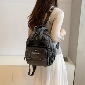 Rückansicht eines lässigen Jeans-Rucksacks, getragen von einem Modell in minimalistischer Umgebung.