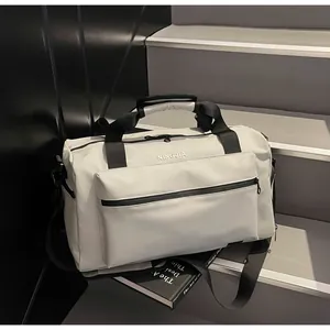 Detailed view of white high-capacity travel duffle bag on dark stairs