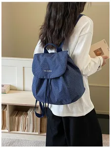 Detailed view of the blue plaid lightweight casual backpack for women in a lifestyle setting