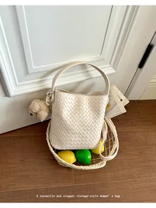 Elegant vintage-style woven bucket bag for women featuring a cute plush bear charm detail