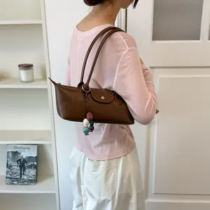 Sac sous l'aisselle marron de niche avec breloques en perles colorées