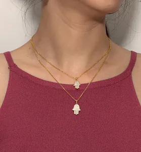 Dettaglio ravvicinato di collana Hamsa in argento S925 placcato oro con intarsio di zirconi