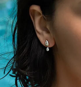 Close-up of S925 sterling silver pear-shaped zircon earrings worn on an ear.