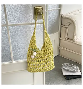 Bolso de hombro calado de ganchillo amarillo con un amuleto de tulipán blanco en la puerta