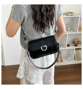 Rückansicht einer schwarzen minimalistischen Umhängetasche an einem Model im Alltag.