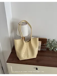 Elegant beige woven leather tote bag with large capacity in a vintage home setting
