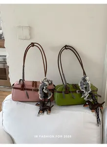 Detail shot of pink and green Boston bags with lace scarves and dachshund charms on a sofa.