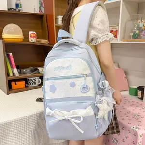 Back view of a cute light blue school backpack with a white bow and star pendant