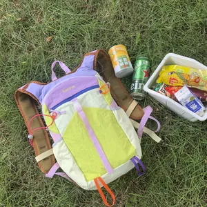 Vibrant dopamine-colored outdoor hiking backpack for women in a picnic grass setting