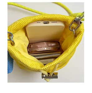 Detail showing the large interior capacity of the yellow mesh bucket bag with essentials inside.