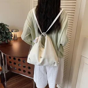 Back view of a white multi-functional backpack with butterfly embroidery and charm
