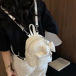 Detailansicht eines stylischen weißen Mini-Rucksacks mit großer Schleife an einem Modell.