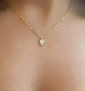 Dettaglio ravvicinato di una collana mano di Fatima in argento S925 dorato con zirconi brillanti.