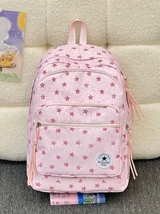Pink backpack featuring all-over red star print patterns and long decorative tassels