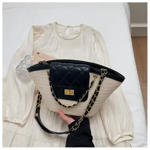 Détail du sac panier en paille avec rabat matelassé noir et bandoulière chaîne