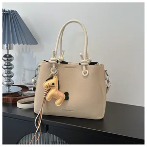 Elegant beige bucket bag featuring a cute horse charm in a minimalist lifestyle setting