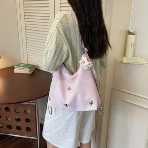Detailed view of lavender butterfly commuter bag with cute rabbit pendant on a model